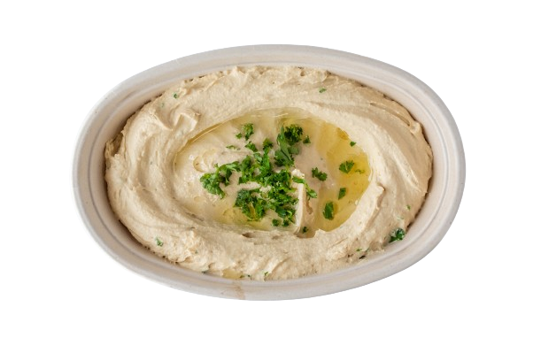 A white bowl of hummus with green onions.